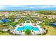 Aerial view of a luxurious pool, clubhouse, and tennis courts surrounded by lush landscaping in a planned community at 5416 Hope Sound Cir, Sarasota, FL 34238