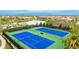 Aerial view of tennis courts, pond, and neatly arranged homes showcasing the community's amenities and layout at 5416 Hope Sound Cir, Sarasota, FL 34238