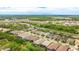 Expansive aerial view of a residential neighborhood with lush greenery and a glimpse of a community pond at 5416 Hope Sound Cir, Sarasota, FL 34238