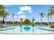Large community pool surrounded by palm trees, lounge chairs, and beautifully landscaped grounds at 5416 Hope Sound Cir, Sarasota, FL 34238