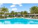 Wide view of a community pool, palm trees, lounge chairs, and clubhouse create a resort-like atmosphere at 5416 Hope Sound Cir, Sarasota, FL 34238