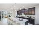 Modern kitchen boasts dark cabinetry, granite countertops, stainless steel appliances, and island seating at 5416 Hope Sound Cir, Sarasota, FL 34238