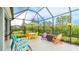 The screened lanai is perfect for relaxing and entertaining, featuring colorful seating and a peaceful backyard view at 5416 Hope Sound Cir, Sarasota, FL 34238