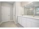Bathroom featuring double sinks, white cabinets, and a glass shower at 5454 Rhapsody Ave, North Port, FL 34288