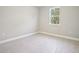 Minimalist bedroom with a large window providing natural light over sleek gray wood look ceramic tile at 5454 Rhapsody Ave, North Port, FL 34288