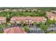 Aerial view of condominium complex with red tile roofs, surrounded by lush greenery and parking lots at 5691 Bentgrass Dr # 211, Sarasota, FL 34235
