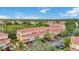 Aerial view of condominium complex with red tile roofs, surrounded by lush greenery and mature trees at 5691 Bentgrass Dr # 211, Sarasota, FL 34235