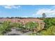 Aerial view of condominium complex with red tile roofs, mature trees, and ample parking at 5691 Bentgrass Dr # 211, Sarasota, FL 34235