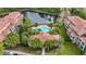 Beautiful aerial view of a community pool, clubhouse, and pond surrounded by mature tropical landscaping at 5691 Bentgrass Dr # 211, Sarasota, FL 34235