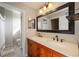 Bathroom featuring dual sinks, plenty of mirror space, and a view of the toilet room at 5691 Bentgrass Dr # 211, Sarasota, FL 34235