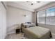 Cozy bedroom with a ceiling fan, large window, and geometric-patterned rug on the hardwood floors at 5691 Bentgrass Dr # 211, Sarasota, FL 34235