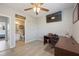 Bedroom featuring wood-look floors, a ceiling fan, a flat screen TV, and an adjacent bathroom at 5691 Bentgrass Dr # 211, Sarasota, FL 34235
