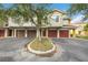 Townhome complex with red-roofs and garage doors and mature trees along the well-maintained street at 5691 Bentgrass Dr # 211, Sarasota, FL 34235