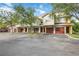 Townhome complex with red-roofs and garage doors and mature trees along the well-maintained street at 5691 Bentgrass Dr # 211, Sarasota, FL 34235