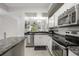 Open concept kitchen with stainless appliances, granite counters and view of living area at 5691 Bentgrass Dr # 211, Sarasota, FL 34235
