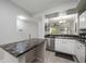Open concept kitchen with stainless appliances, granite counters and view of living area at 5691 Bentgrass Dr # 211, Sarasota, FL 34235