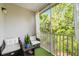 Screened-in patio with artificial turf flooring and outdoor seating for a comfortable space with tree views at 5691 Bentgrass Dr # 211, Sarasota, FL 34235
