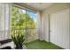 Screened-in patio with artificial turf flooring providing a tranquil outdoor space with tree views at 5691 Bentgrass Dr # 211, Sarasota, FL 34235