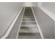 Carpeted staircase with gray walls, carpet, and a white railing providing a safe transition to the upper level at 5691 Bentgrass Dr # 211, Sarasota, FL 34235