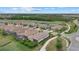 Aerial view showcasing homes within a community bordered by a golf course, ponds, and lush greenery at 5811 Brandon Run, Bradenton, FL 34211