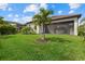 Backyard featuring green lawn, mature trees, and a screened-in lanai at 5811 Brandon Run, Bradenton, FL 34211