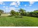 Lush backyard featuring well-manicured lawn and tropical landscaping at 5811 Brandon Run, Bradenton, FL 34211
