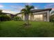 Landscaped backyard with green lawn, mature trees, and a screened lanai at 5811 Brandon Run, Bradenton, FL 34211