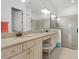 Bathroom featuring double sinks, granite counters, large mirror, and tiled shower at 5811 Brandon Run, Bradenton, FL 34211