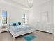 Bright bedroom features a tray ceiling, ensuite bathroom, and neutral decor at 5811 Brandon Run, Bradenton, FL 34211