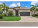 Charming single-story home with a well-manicured lawn, palm trees, paved driveway, and a gray garage door at 5811 Brandon Run, Bradenton, FL 34211