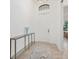 Bright foyer features tile flooring, a decorative table, an arched window above the front door, and white walls at 5811 Brandon Run, Bradenton, FL 34211