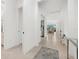 Bright hallway featuring tile flooring leading to a living area, with a console table and white walls at 5811 Brandon Run, Bradenton, FL 34211