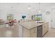 Open concept kitchen offers stainless appliances, custom cabinets, granite counters, a center island, and tiled floors at 5811 Brandon Run, Bradenton, FL 34211