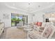 Inviting living room featuring cozy seating, a glass table, and sliding glass doors with a view of the beautiful backyard at 5811 Brandon Run, Bradenton, FL 34211