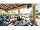Covered outdoor dining area with tables, chairs, and a view of the pool, ideal for entertaining at 5811 Brandon Run, Bradenton, FL 34211
