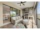 Outdoor screened patio with a built-in kitchen featuring a grill, a stone backsplash, and stylish seating with a ceiling fan at 5811 Brandon Run, Bradenton, FL 34211