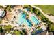 Aerial view of a community pool area featuring multiple pools, lush landscaping, and lounge chairs for relaxing at 5811 Brandon Run, Bradenton, FL 34211