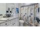 Charming bathroom with a seashell-themed shower curtain and granite countertop vanity at 5917 Cessna Run, Lakewood Ranch, FL 34211