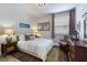 Cozy bedroom with neutral tones, a queen bed, and ample natural light at 5917 Cessna Run, Lakewood Ranch, FL 34211