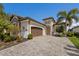 Charming single-Gathering home featuring a stone facade, a 2-car garage, and lush tropical landscaping at 5917 Cessna Run, Lakewood Ranch, FL 34211