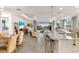 Open-concept living room and kitchen with a view of the pool and golf course through sliding glass doors at 5917 Cessna Run, Lakewood Ranch, FL 34211