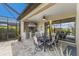 The outdoor kitchen has stainless steel appliances, stone backsplash, and is covered with an outdoor dining space at 5917 Cessna Run, Lakewood Ranch, FL 34211
