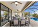 Outdoor dining area on a screened lanai overlooking a pool and lush landscaping at 5917 Cessna Run, Lakewood Ranch, FL 34211