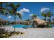 Community pool with a waterfall and lounge chairs surrounded by palm trees under a partly cloudy sky at 5917 Cessna Run, Lakewood Ranch, FL 34211