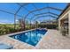 The screened-in pool has a spa and lush landscaping, surrounded by brick pavers at 5917 Cessna Run, Lakewood Ranch, FL 34211