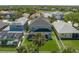 Aerial view of the back of a gray home with a backyard and palm trees at 6210 Laurel Creek Trl, Ellenton, FL 34222