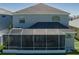 Rear exterior with an enclosed lanai and a gray facade under a gray roof at 6210 Laurel Creek Trl, Ellenton, FL 34222