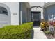 Inviting front entrance features a decorative door, manicured bushes, and the house number at 6210 Laurel Creek Trl, Ellenton, FL 34222