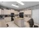 Bright eat-in kitchen with tiled floors, a center island, light cabinets and modern appliances at 6210 Laurel Creek Trl, Ellenton, FL 34222