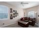 Cozy sitting room features a leather sofa and ottoman with natural light from large windows at 6210 Laurel Creek Trl, Ellenton, FL 34222